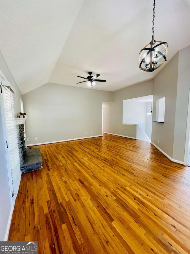 350 Fall View Ct, Winder, GA 30680 - unfurnished living room with vaulted ceiling, a chandelier, wood-type flooring, a fireplace with raised hearth, and ceiling fan