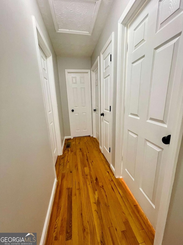 350 Fall View Ct, Winder, GA 30680 - hallway featuring wood finished floors, attic access, and a textured ceiling