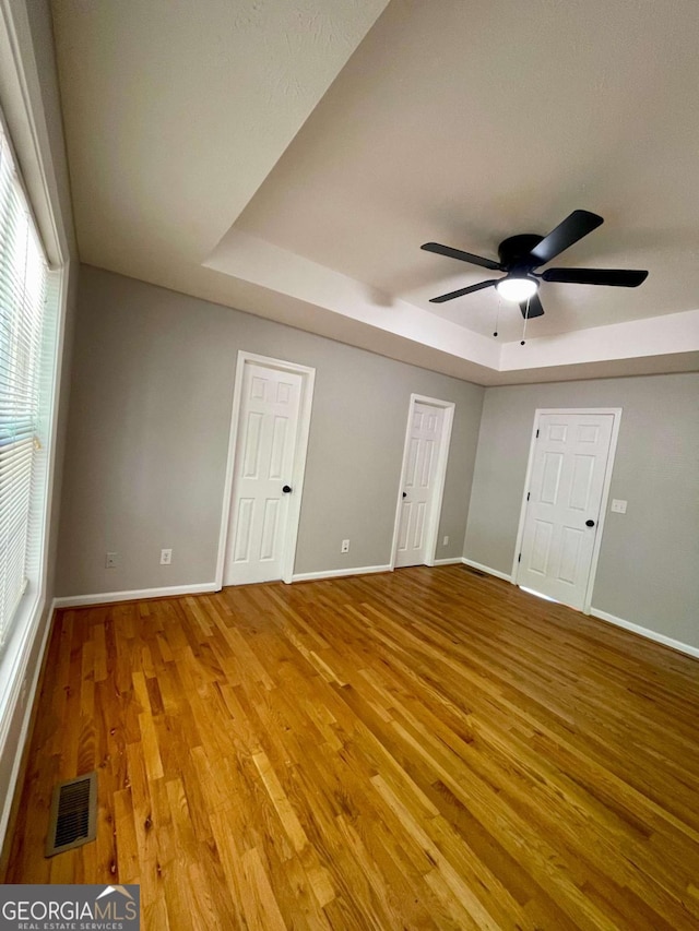 350 Fall View Ct, Winder, GA 30680 - spare room with a tray ceiling, wood finished floors, and a ceiling fan
