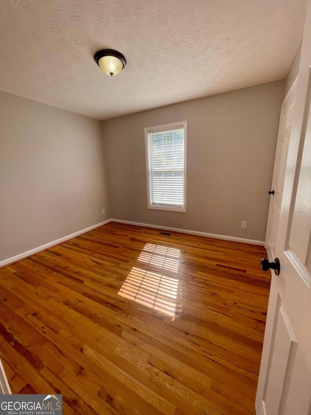 350 Fall View Ct, Winder, GA 30680 - spare room featuring wood finished floors and a textured ceiling