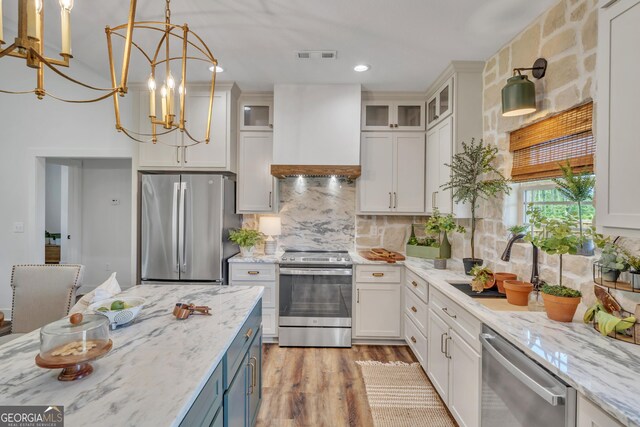 1354 Lakeway Rd, East Dublin, GA 31027 - kitchen with appliances with stainless steel finishes, custom range hood, light wood-style floors, decorative backsplash, and white cabinets