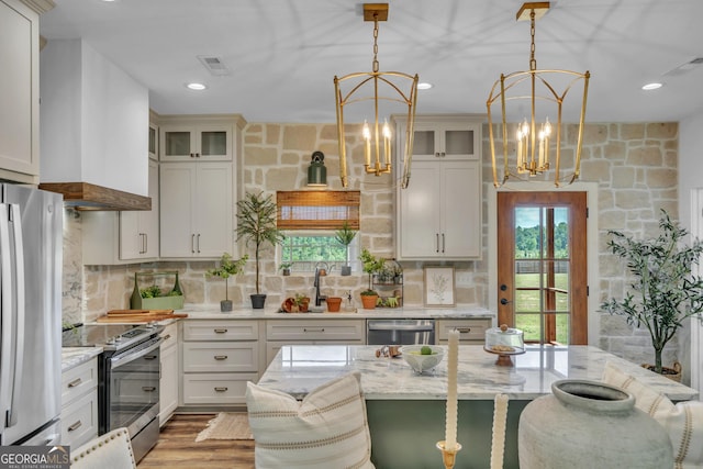 1354 Lakeway Rd, East Dublin, GA 31027 - kitchen featuring stainless steel appliances, a chandelier, a kitchen bar, tasteful backsplash, and light stone countertops