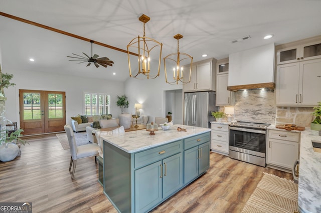 1354 Lakeway Rd, East Dublin, GA 31027 - kitchen featuring appliances with stainless steel finishes, tasteful backsplash, vaulted ceiling, hanging light fixtures, and light wood-style flooring