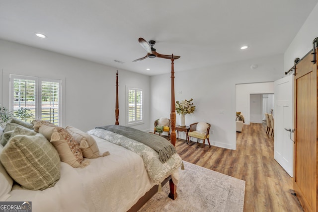 1354 Lakeway Rd, East Dublin, GA 31027 - bedroom featuring a barn door, multiple windows, light wood-type flooring, recessed lighting, and ceiling fan