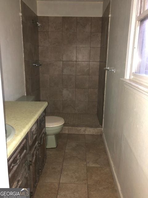 405 Tumbleweed Cir, Centerville, GA 31028 - full bathroom featuring vanity, toilet, a tile shower, and tile patterned floors