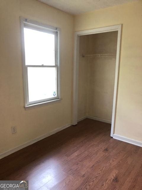 405 Tumbleweed Cir, Centerville, GA 31028 - unfurnished bedroom with dark wood finished floors, multiple windows, baseboards, and a closet