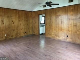 405 Tumbleweed Cir, Centerville, GA 31028 - spare room featuring wooden walls, wood finished floors, ceiling fan, and vaulted ceiling
