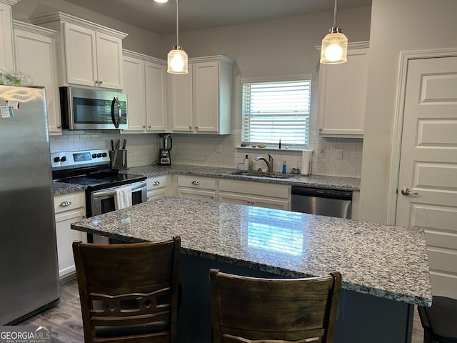 2289 Remington Dr, Commerce, GA 30529 - kitchen featuring stainless steel appliances, a sink, a kitchen bar, and white cabinetry
