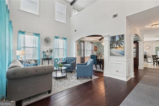 1017 Preserve Park Dr, Loganville, GA 30052 - living area with decorative columns, arched walkways, hardwood / wood-style floors, a high ceiling, and healthy amount of natural light