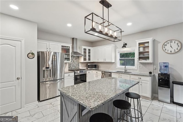 1017 Preserve Park Dr, Loganville, GA 30052 - kitchen featuring stainless steel appliances, light marble finish flooring, wall chimney exhaust hood, a kitchen breakfast bar, and recessed lighting