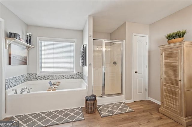 1017 Preserve Park Dr, Loganville, GA 30052 - full bath featuring a shower stall, a bath, wood finished floors, and a closet