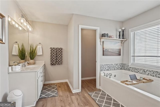 1017 Preserve Park Dr, Loganville, GA 30052 - bathroom featuring vanity, wood finished floors, and a garden tub