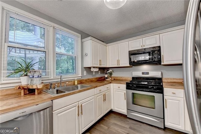 10000 Barston Ct, Johns Creek, GA 30022 - kitchen with appliances with stainless steel finishes, white cabinetry, a textured ceiling, dark wood finished floors, and wood counters