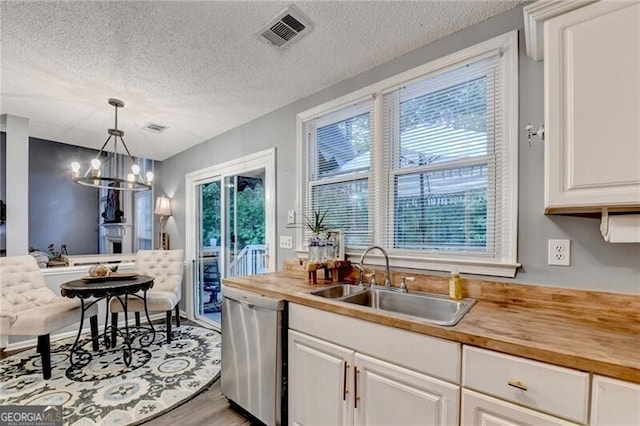 10000 Barston Ct, Johns Creek, GA 30022 - kitchen with dishwasher, wooden counters, a textured ceiling, white cabinetry, and hanging light fixtures
