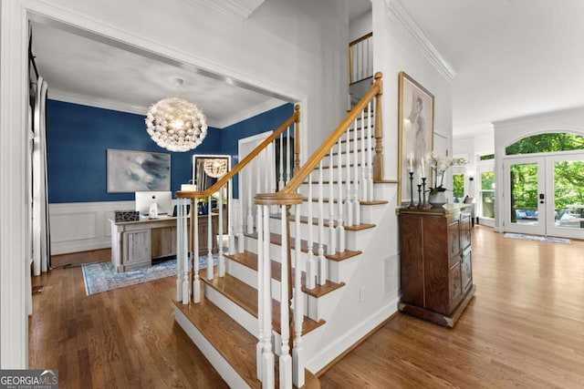 2936 Summitop Rd NE, Marietta, GA 30066 - stairway featuring crown molding, wood finished floors, a chandelier, french doors, and a wainscoted wall