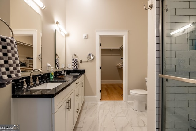 1 E 3rd Ave Unit 302, Rome, GA 30161 - bathroom featuring double vanity, marble look tile flooring, a walk in closet, toilet, and tiled shower