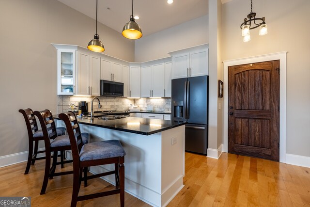 1 E 3rd Ave Unit 302, Rome, GA 30161 - kitchen featuring black appliances, a peninsula, dark countertops, a kitchen breakfast bar, and backsplash