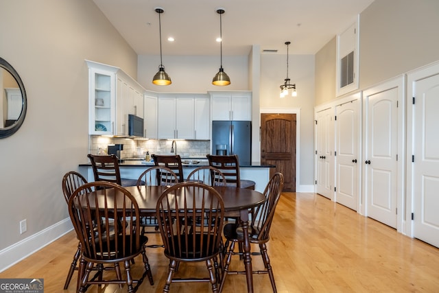 1 E 3rd Ave Unit 302, Rome, GA 30161 - dining room featuring a towering ceiling, baseboards, and light wood-type flooring
