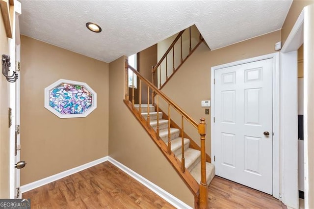 916 Forest Pointe Way, Jonesboro, GA 30238 - foyer entrance featuring wood finished floors, stairway, a textured ceiling, and baseboards