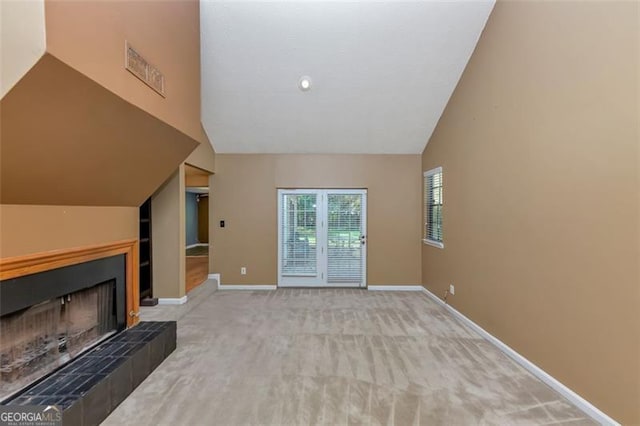 916 Forest Pointe Way, Jonesboro, GA 30238 - unfurnished living room featuring baseboards, carpet flooring, a tiled fireplace, and high vaulted ceiling