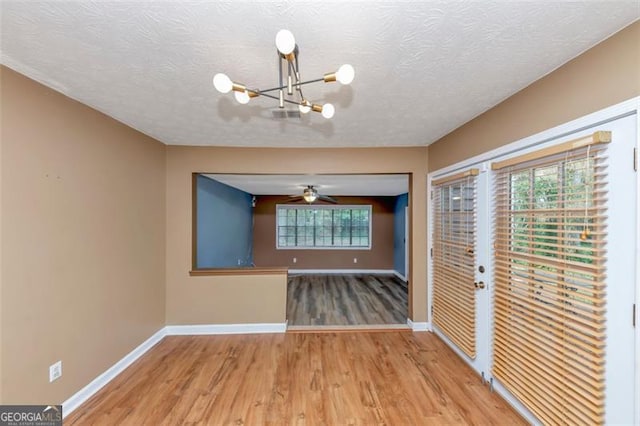 916 Forest Pointe Way, Jonesboro, GA 30238 - spare room featuring a chandelier, baseboards, wood finished floors, plenty of natural light, and a textured ceiling