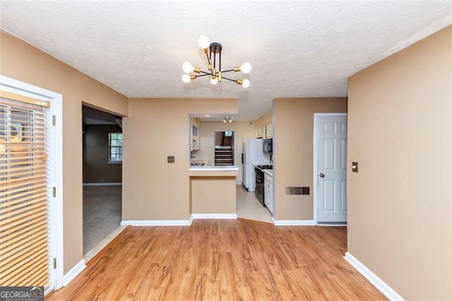916 Forest Pointe Way, Jonesboro, GA 30238 - unfurnished living room featuring a chandelier, baseboards, light wood-style floors, and a textured ceiling