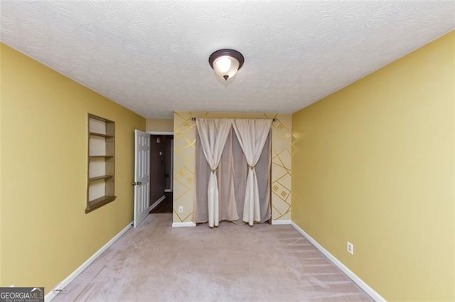 916 Forest Pointe Way, Jonesboro, GA 30238 - unfurnished room with baseboards, carpet flooring, built in features, and a textured ceiling