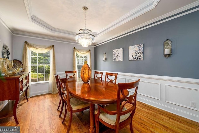 2484 Mossy Branch Dr, Snellville, GA 30078 - dining space with a chandelier, wood finished floors, a tray ceiling, a wainscoted wall, and ornamental molding