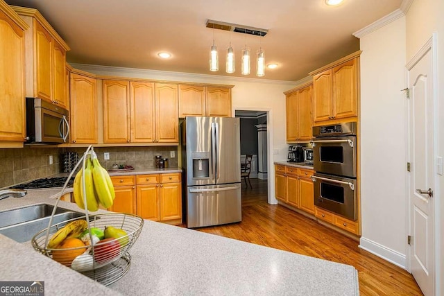2484 Mossy Branch Dr, Snellville, GA 30078 - kitchen featuring appliances with stainless steel finishes, ornamental molding, decorative backsplash, a sink, and light countertops