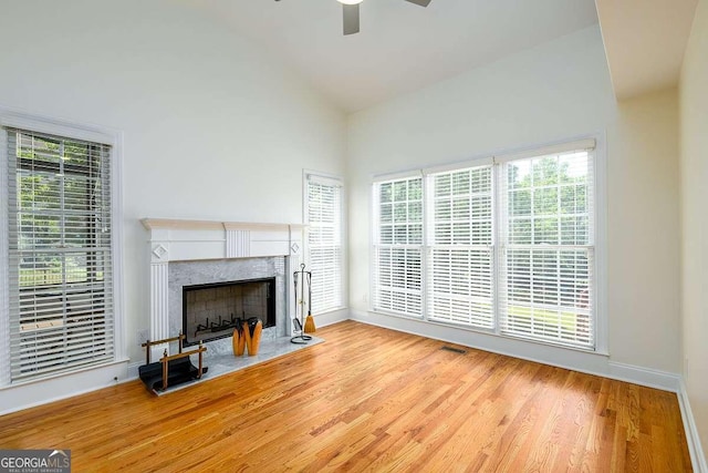 2484 Mossy Branch Dr, Snellville, GA 30078 - living area featuring a ceiling fan, a premium fireplace, baseboards, wood finished floors, and high vaulted ceiling