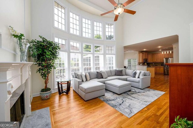 2484 Mossy Branch Dr, Snellville, GA 30078 - living room with ceiling fan, a towering ceiling, plenty of natural light, and a fireplace with flush hearth