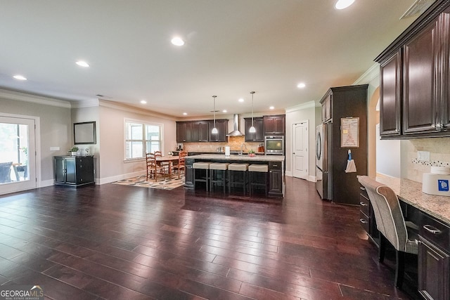 265 Enfield Ln, Mcdonough, GA 30252 - kitchen with appliances with stainless steel finishes, ornamental molding, wall chimney range hood, a breakfast bar, and backsplash