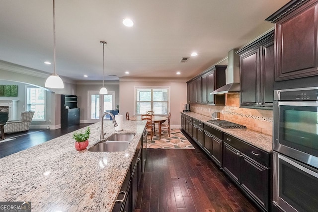 265 Enfield Ln, Mcdonough, GA 30252 - kitchen featuring a sink, wall chimney range hood, appliances with stainless steel finishes, light stone counters, and crown molding