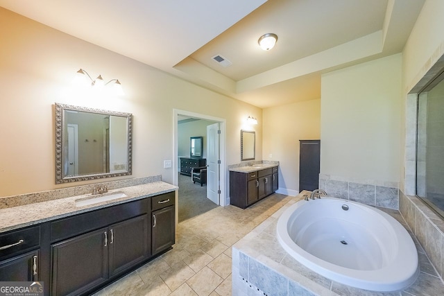 265 Enfield Ln, Mcdonough, GA 30252 - full bathroom featuring a garden tub, two vanities, and a raised ceiling