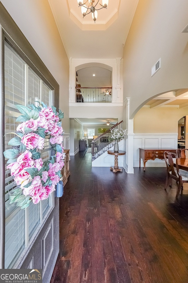 265 Enfield Ln, Mcdonough, GA 30252 - entrance foyer featuring arched walkways, a high ceiling, a raised ceiling, wood-type flooring, and crown molding
