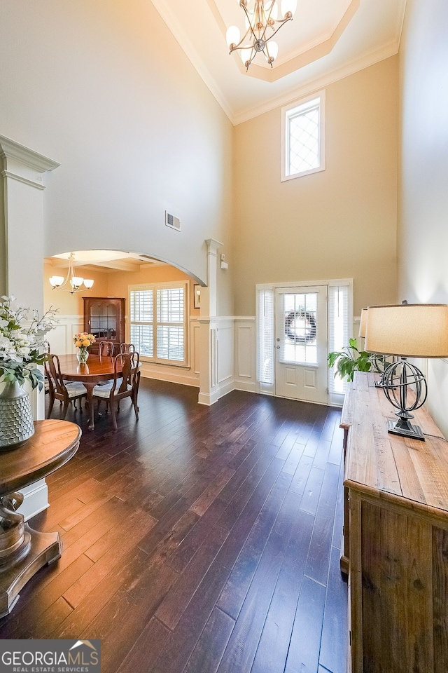 265 Enfield Ln, Mcdonough, GA 30252 - entrance foyer featuring a chandelier, arched walkways, a high ceiling, dark wood-style floors, and ornamental molding