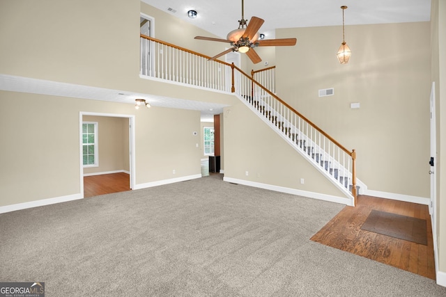 4000 Mcpherson Dr, Acworth, GA 30101 - unfurnished living room with carpet, ceiling fan, a high ceiling, plenty of natural light, and stairway