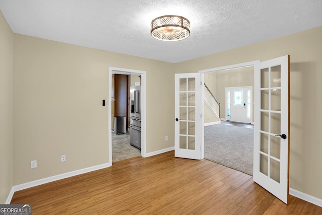4000 Mcpherson Dr, Acworth, GA 30101 - spare room with french doors, light wood-style floors, and a textured ceiling