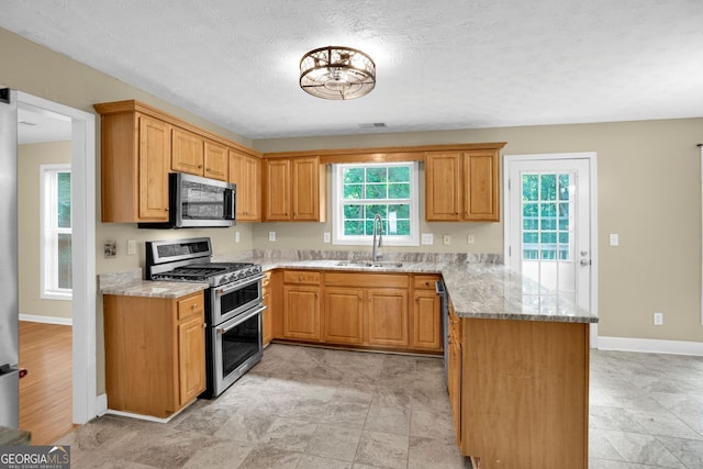 4000 Mcpherson Dr, Acworth, GA 30101 - kitchen with appliances with stainless steel finishes, a peninsula, light stone counters, and a textured ceiling