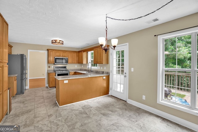 4000 Mcpherson Dr, Acworth, GA 30101 - kitchen featuring appliances with stainless steel finishes, a peninsula, healthy amount of natural light, and light countertops