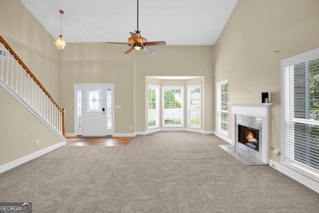 4000 Mcpherson Dr, Acworth, GA 30101 - unfurnished living room featuring high vaulted ceiling, carpet, stairs, a fireplace, and a ceiling fan