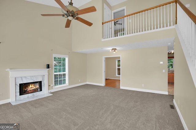 4000 Mcpherson Dr, Acworth, GA 30101 - unfurnished living room featuring carpet flooring, a towering ceiling, ceiling fan, and a high end fireplace