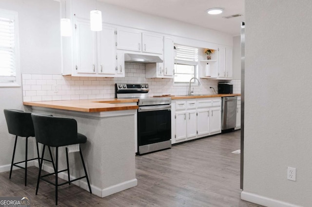 435 Goss Rd, Epworth, GA 30541 - kitchen featuring stainless steel appliances, wooden counters, under cabinet range hood, white cabinets, and decorative backsplash