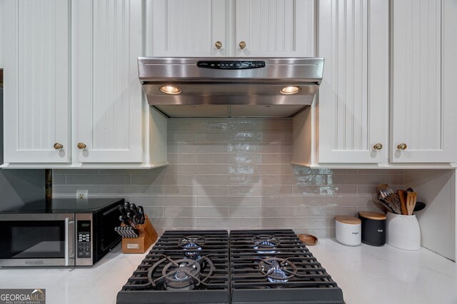 4317 Harold Whelchel Rd, Gainesville, GA 30506 - kitchen with stainless steel microwave, range hood, white cabinets, and tasteful backsplash