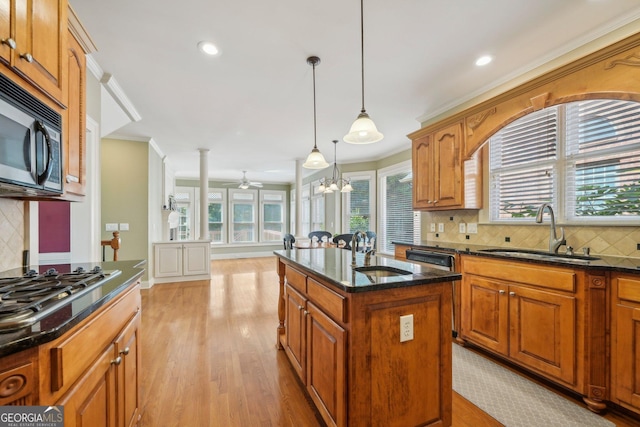 2871 Trailing Ivy Way, Buford, GA 30519 - kitchen with appliances with stainless steel finishes, light wood-style floors, crown molding, decorative backsplash, and pendant lighting