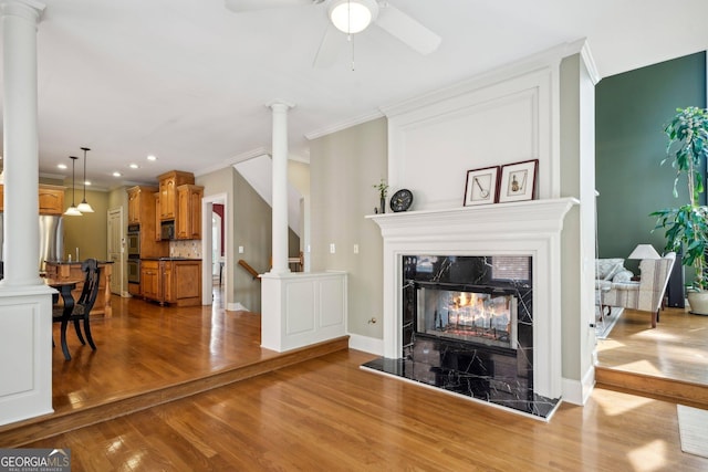 2871 Trailing Ivy Way, Buford, GA 30519 - living area featuring wood finished floors, ornamental molding, decorative columns, ceiling fan, and a fireplace