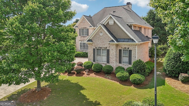 2871 Trailing Ivy Way, Buford, GA 30519 - view of front of house featuring brick siding, a front lawn, a chimney, and roof with shingles