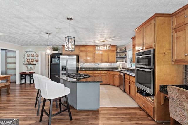 401 Riverwalk, Mcdonough, GA 30252 - kitchen featuring appliances with stainless steel finishes, open shelves, a textured ceiling, a kitchen island, and a sink