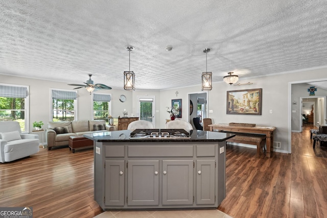 401 Riverwalk, Mcdonough, GA 30252 - kitchen featuring stainless steel gas cooktop, a kitchen island, gray cabinets, dark wood-type flooring, and a textured ceiling