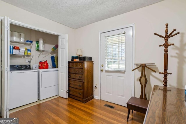 954 Bryant St SW, Conyers, GA 30012 - laundry area featuring independent washer and dryer, wood finished floors, and a textured ceiling